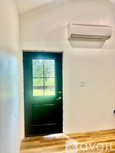 A room with a black door and a window.