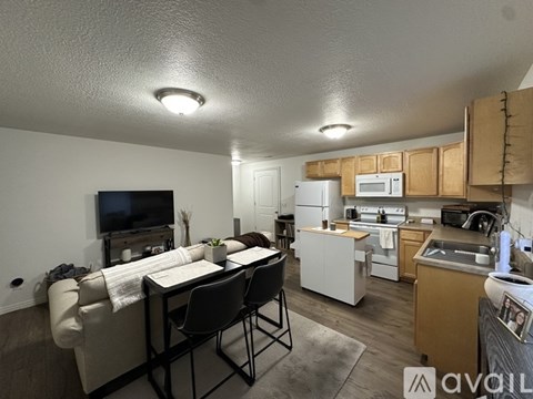 A well-lit kitchen with a dining table and chairs.