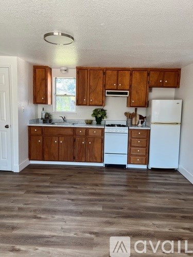 A kitchen with wooden cabinets and a white fridge.