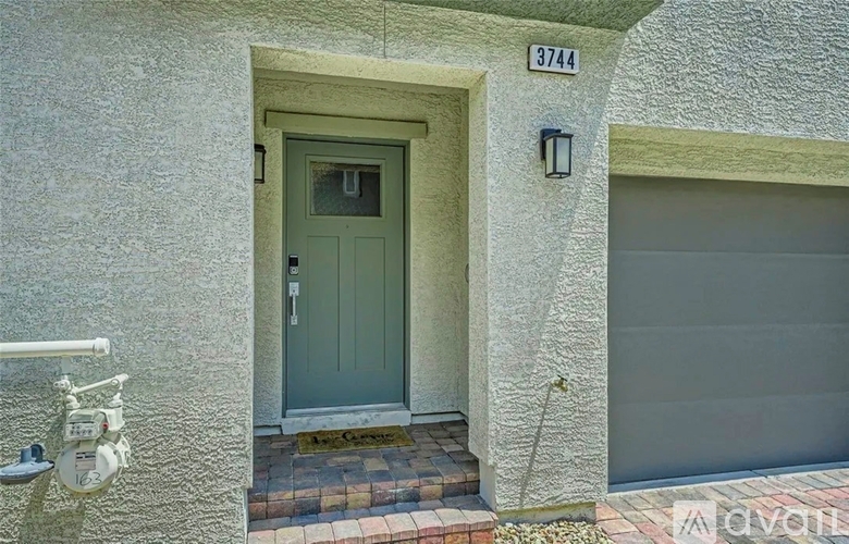A grey door with a glass window is on the front of a house.