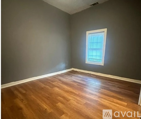 A room with wooden flooring and a window.