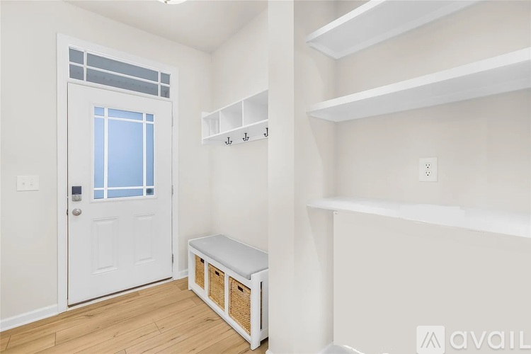 A white door with a window and a bench in a room.