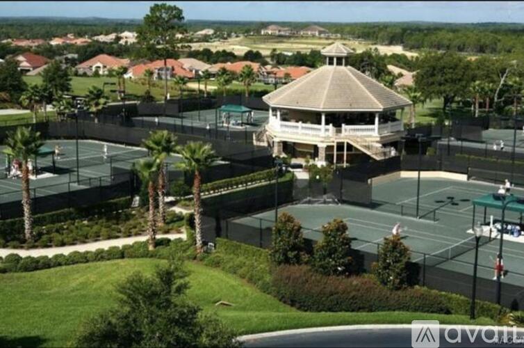 A tennis court with a gazebo in the middle of it.