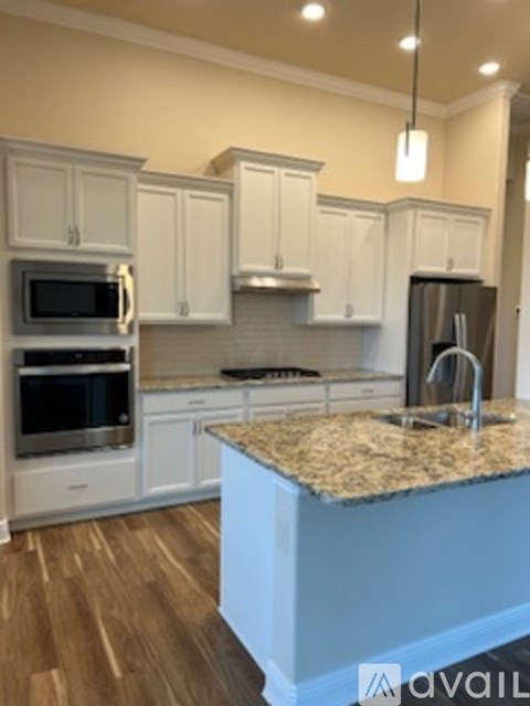 A kitchen with white cabinets and a granite countertop.