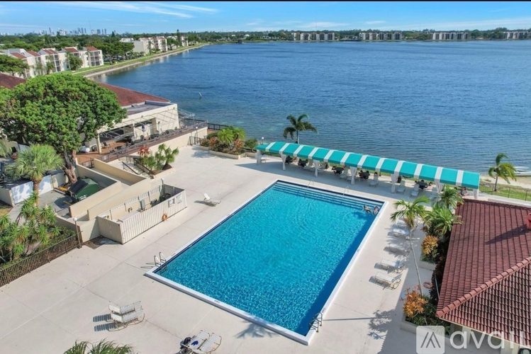 A large swimming pool with a blue tiled edge and a white fence around it.