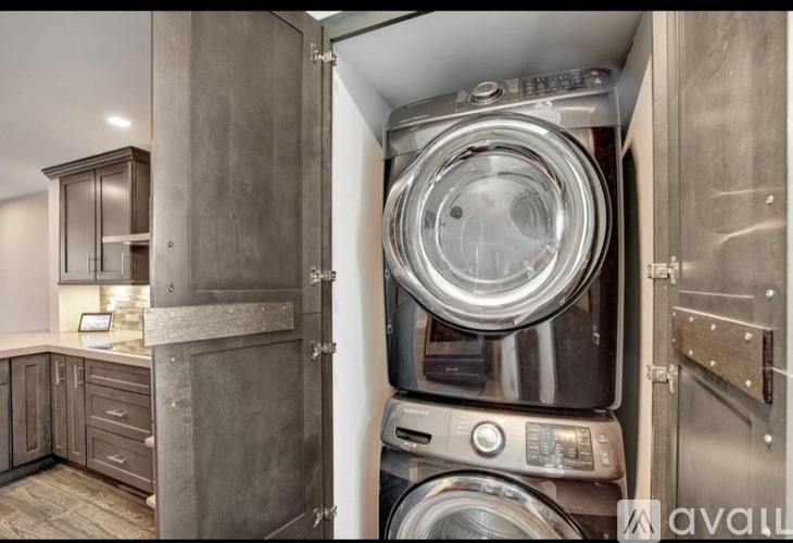 A washing machine is installed in a cabinet in a kitchen.