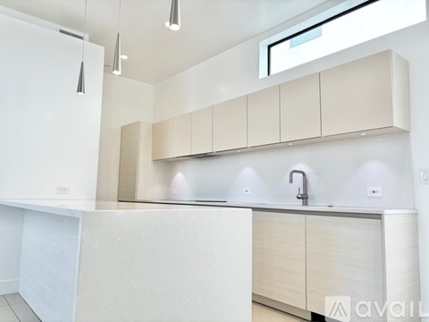 A modern kitchen with white cabinets and a white countertop.