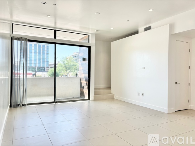 A spacious room with a large window and sliding glass doors.