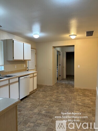 A kitchen with white cabinets and a checkered floor.