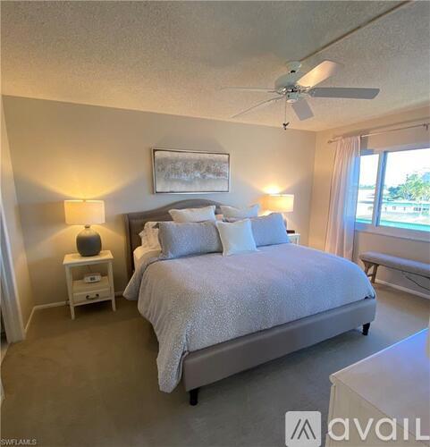 A bedroom with a large bed and a ceiling fan.