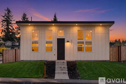 A small house with a front yard and a wooden fence.