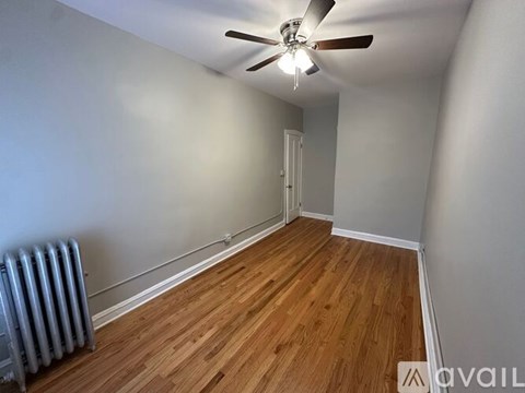 A room with a ceiling fan and wooden flooring.