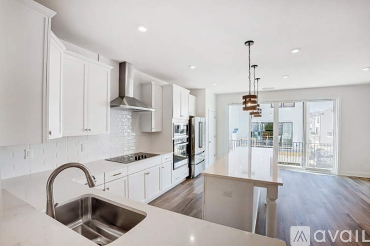 A modern kitchen with white cabinets and a stainless steel sink.