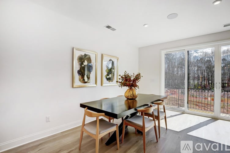A dining room with a table and chairs and two framed pictures on the wall.