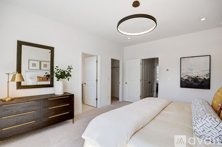 A living room with a white couch and a brown dresser.