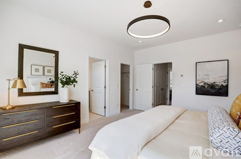A living room with a white couch and a brown dresser.