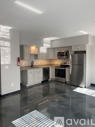 A kitchen with a refrigerator, microwave, and oven.