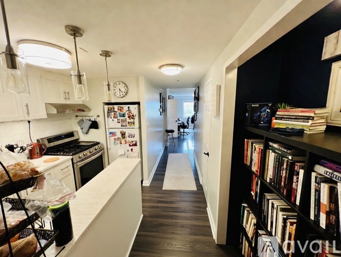 A kitchen with a white counter and a fridge with magnets on it.