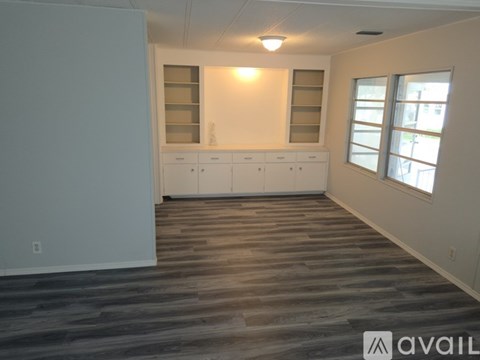 A room with wooden flooring and white walls.