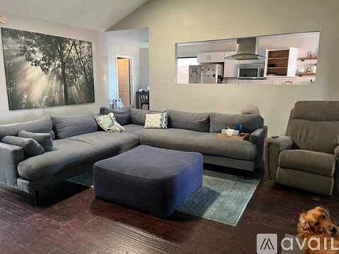 A living room with a grey couch and a blue ottoman.