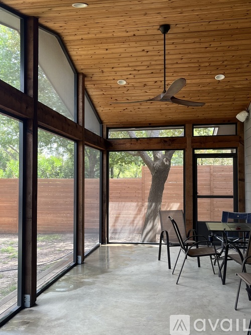 A room with a ceiling fan and sliding glass doors.