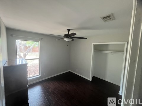 A room with a ceiling fan and a sliding glass door.