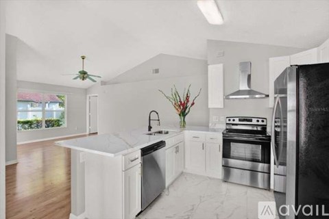A modern kitchen with white appliances and a marble countertop.