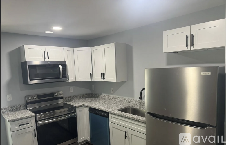 A kitchen with a stainless steel refrigerator, microwave, and oven.