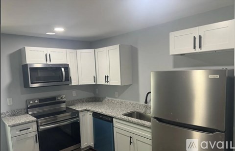 A kitchen with a stainless steel refrigerator, microwave, and oven.