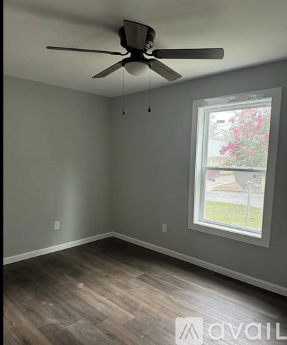 A room with a ceiling fan and a window.