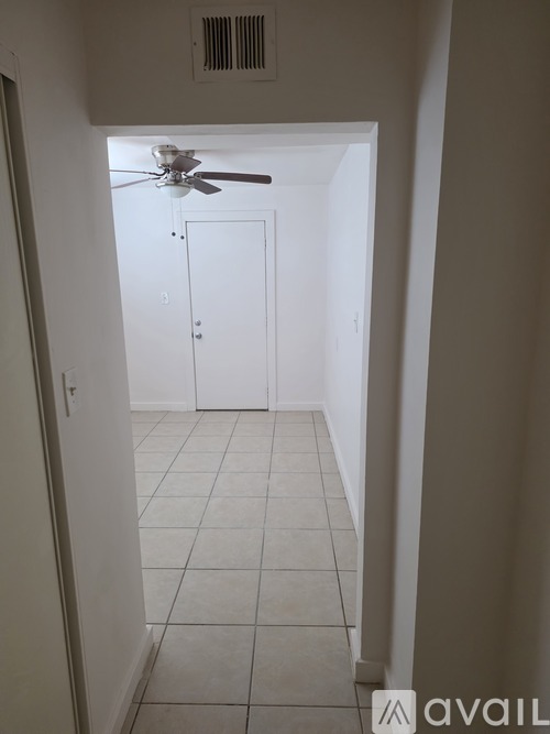 A room with a ceiling fan and a white door.