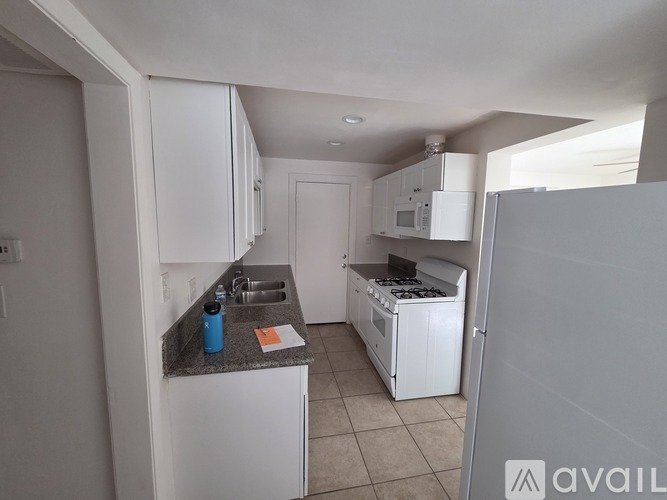 A kitchen with white cabinets and appliances.