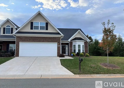 A house with a garage and a driveway in front.