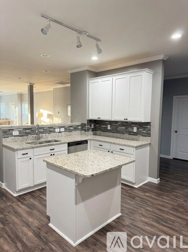 A kitchen with white cabinets and a granite countertop.