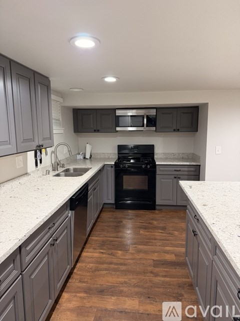 A kitchen with dark wood cabinets and a black oven.