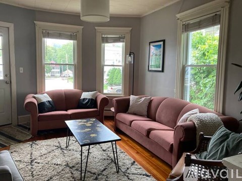 A living room with a red couch and a coffee table.