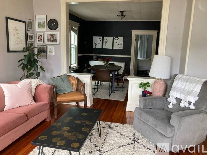 A living room with a pink couch, grey armchair, and a coffee table.