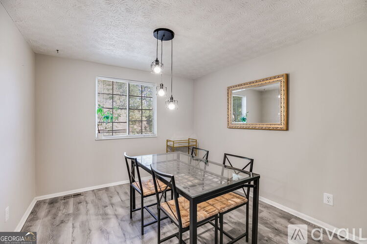 A dining room with a glass table and chairs.