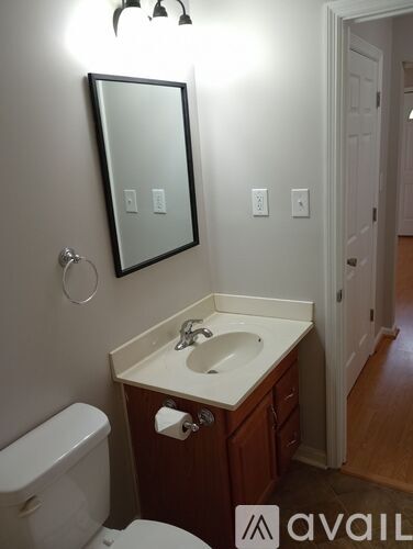 A bathroom with a sink, toilet and mirror.