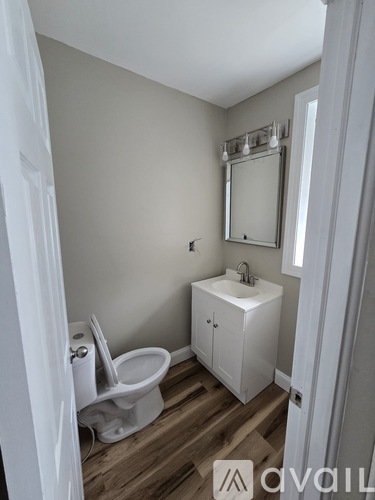 A bathroom with a toilet, sink, and medicine cabinet.