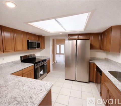 A kitchen with a refrigerator, microwave, and oven.