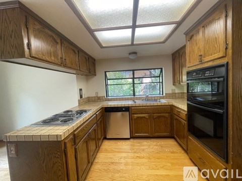 A kitchen with wooden cabinets and a black oven.