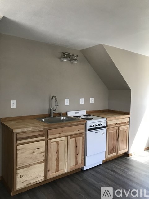 A kitchen with wooden cabinets and a white dishwasher.