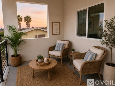 A patio with two chairs, a table, and a plant.