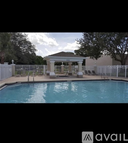 A pool with a gazebo in the background.