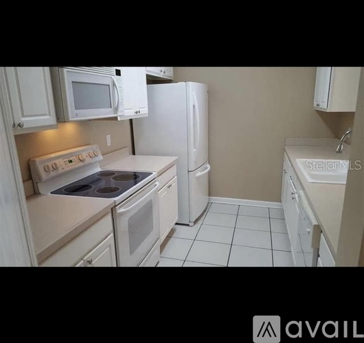 A kitchen with white appliances and cabinets.