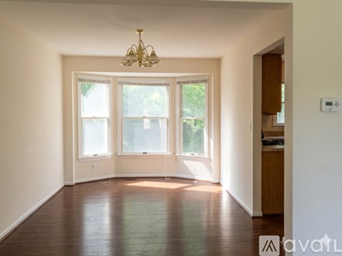 A room with a chandelier, a window, and a door.