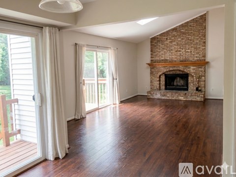 A room with a fireplace and sliding glass doors.