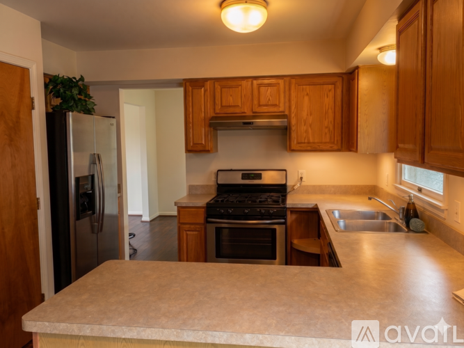 A kitchen with wooden cabinets and a marble countertop.