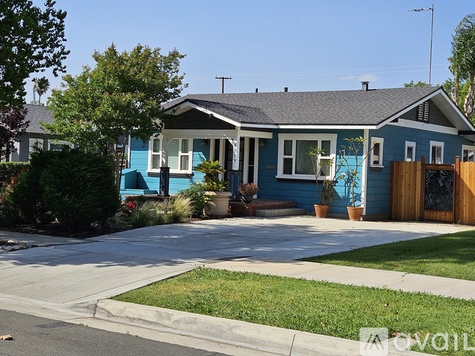 A blue house with a white window and a brown fence.